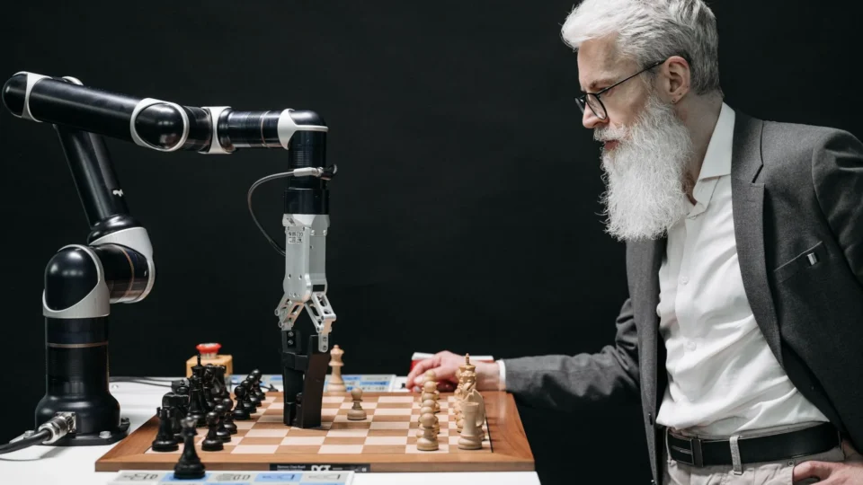 A man plays chess against an AI robotic arm, showcasing technology and strategy innovation.