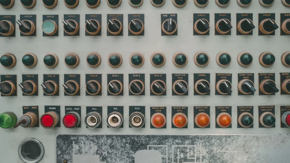 Close-up of a vintage industrial control panel with multiple buttons and switches.