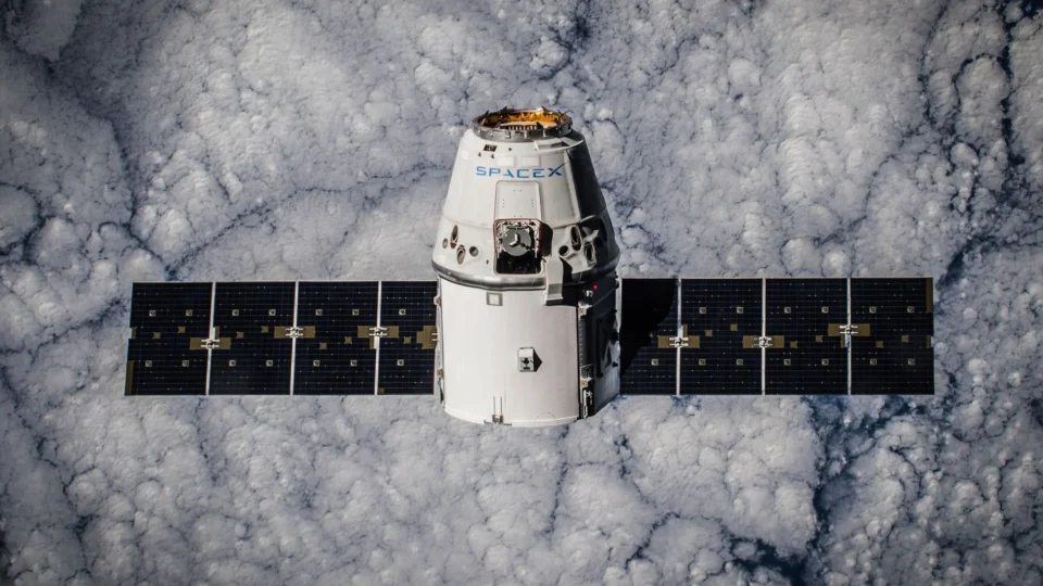 SpaceX Dragon spacecraft in orbit, highlighting advanced space technology with cloud backdrop.