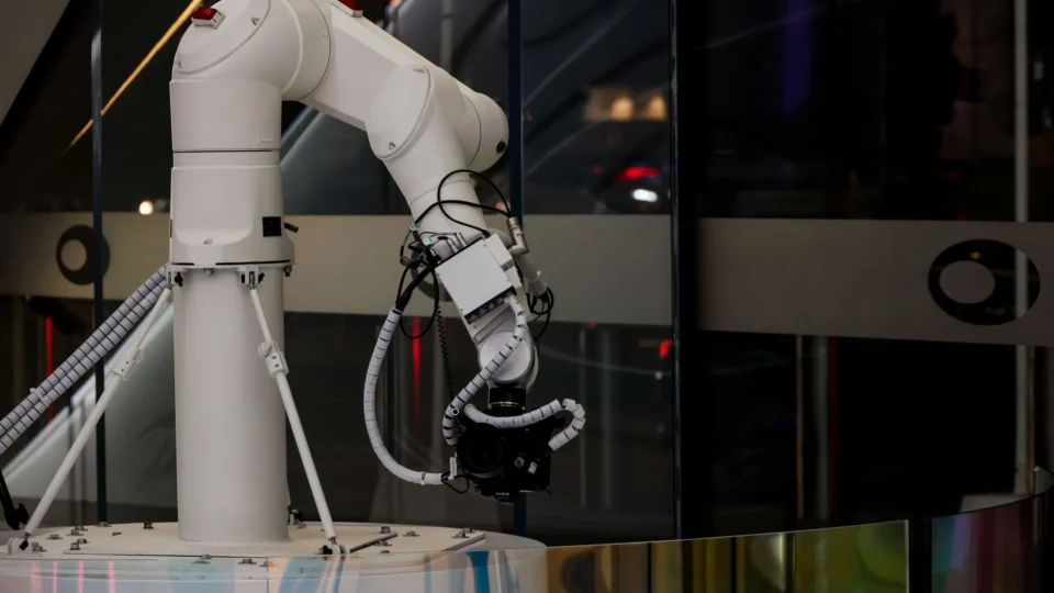 A white robotic arm operating indoors with a modern design and advanced technology.