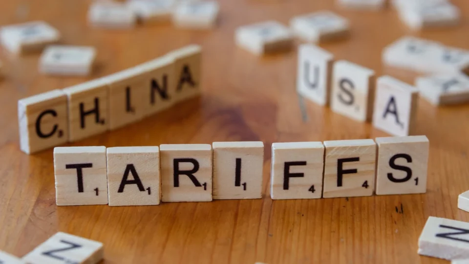 Wooden letter blocks spelling tariffs, China, and USA representing trade relations.