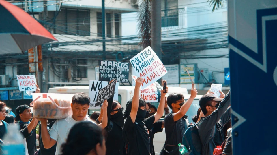 A vibrant urban protest scene with demonstrators holding signs, expressing political messages.