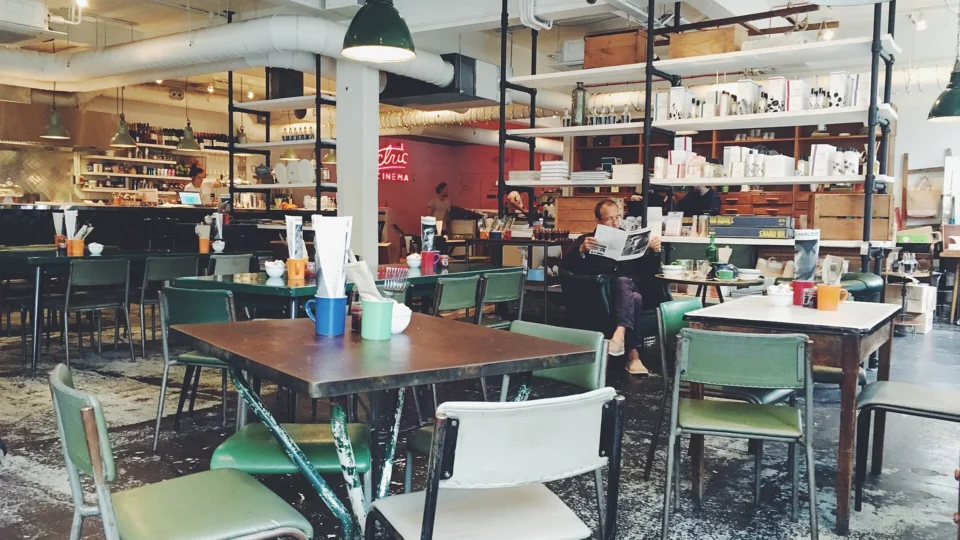 A man reading a newspaper alone in a café