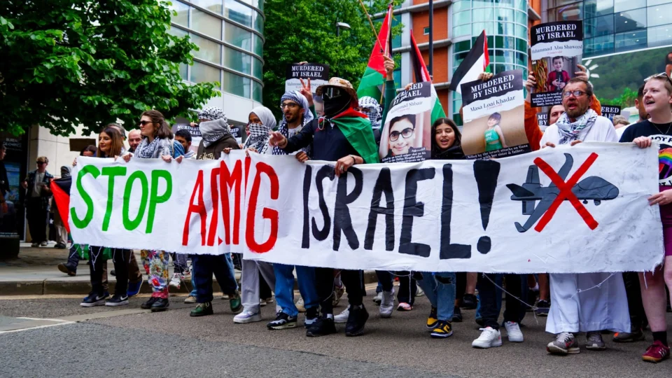 People march in Manchester advocating for peace in Palestine during a street protest.
