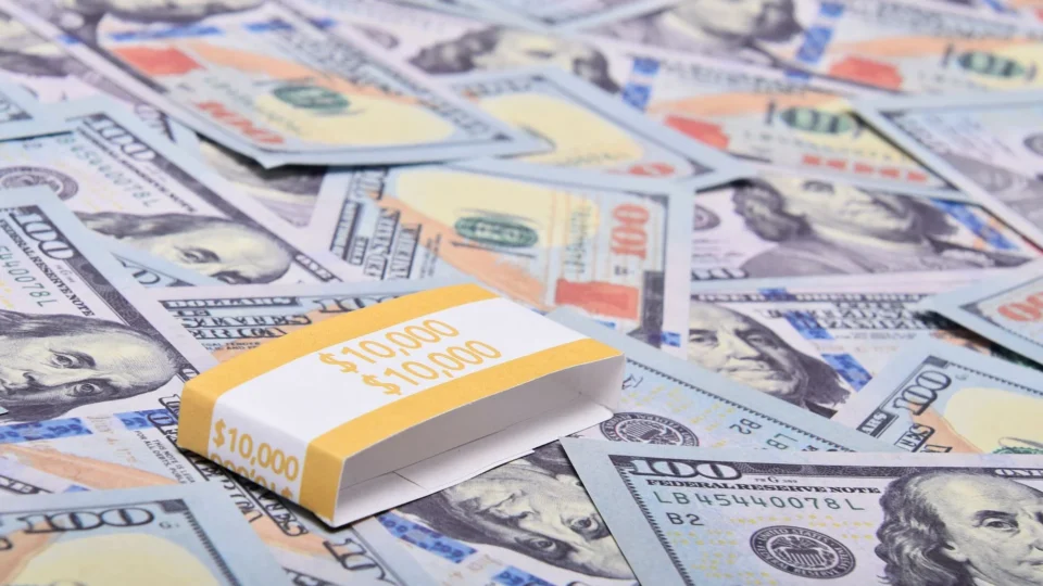 A stack of $100 bills arranged on a surface with US dollar notes. Ideal for finance themes.