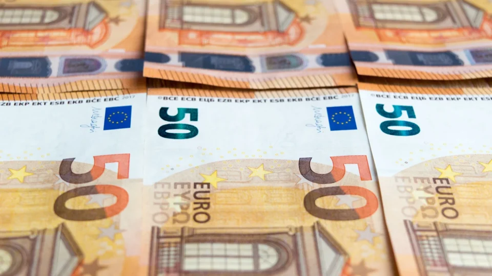 Detailed image of multiple 50 Euro bills stacked, showcasing currency design.