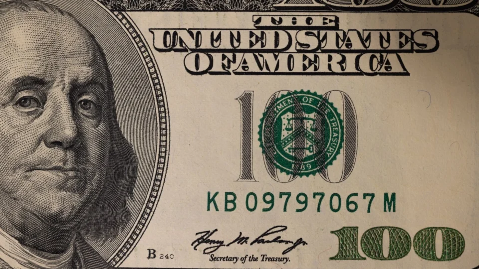Detailed close-up image of a US one hundred dollar bill showing Benjamin Franklin.