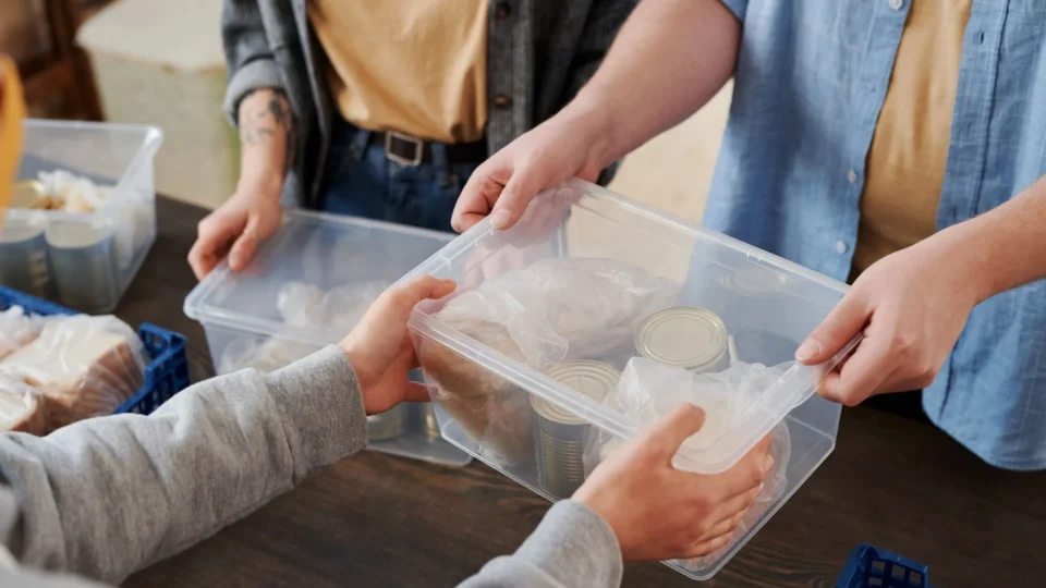 Close-up of volunteers distributing food packages during a charity event.
