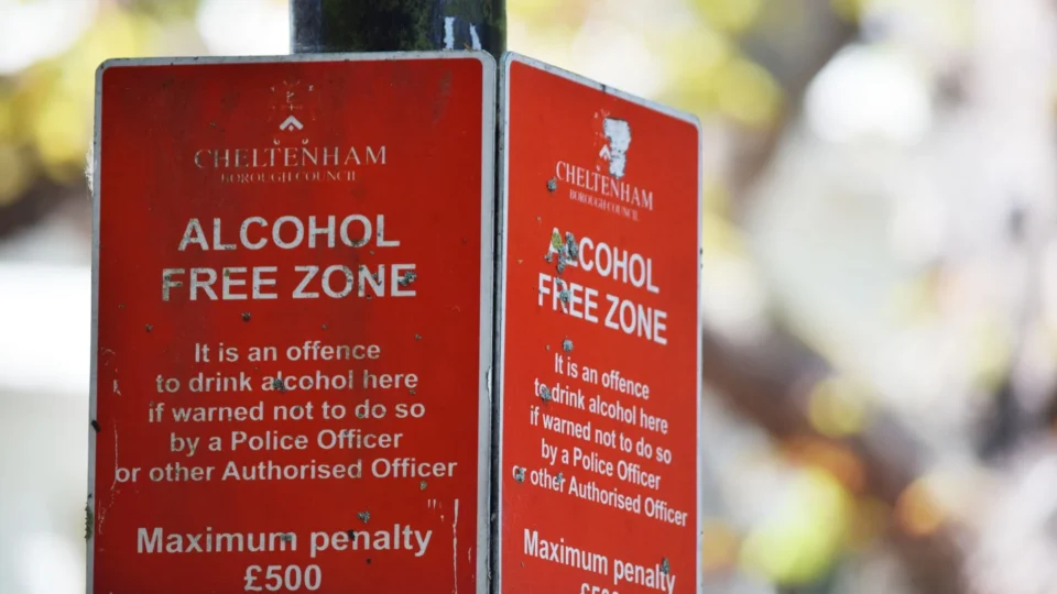 Close-up of red Cheltenham alcohol-free zone sign with maximum penalty warning.