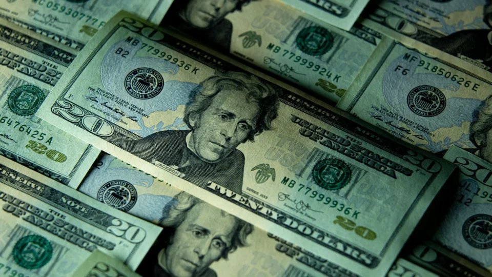 Close-up of multiple US twenty dollar bills depicting wealth and finance.