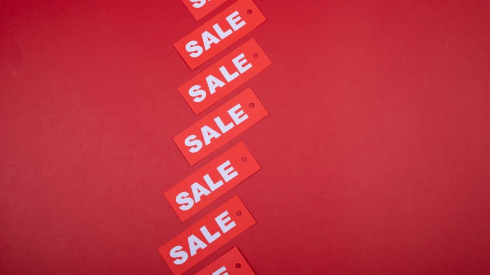 Red sale tags aligned diagonally on a red background, perfect for retail promotions.
