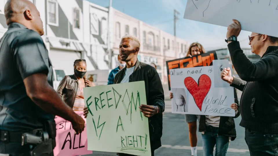 A diverse group of people peacefully protesting for freedoms and world peace in an urban setting.