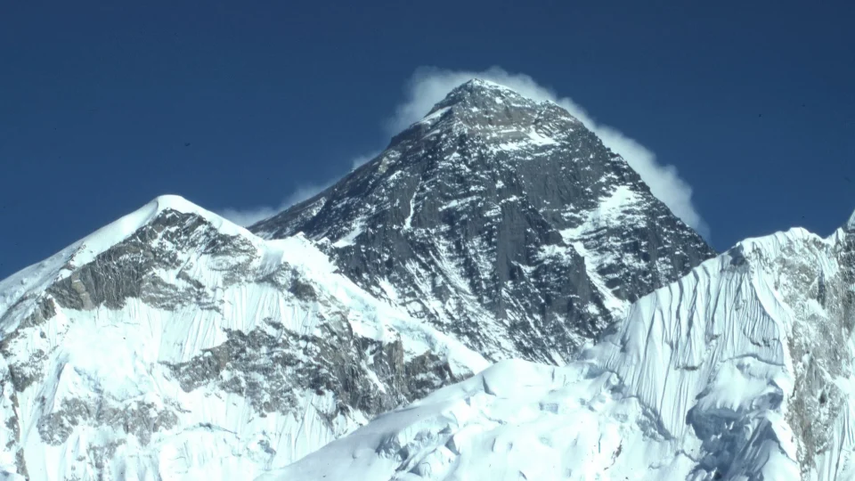 Majestic winter view of snow-covered Mount Everest under a clear blue sky, captured from Khumjung, Nepal.
