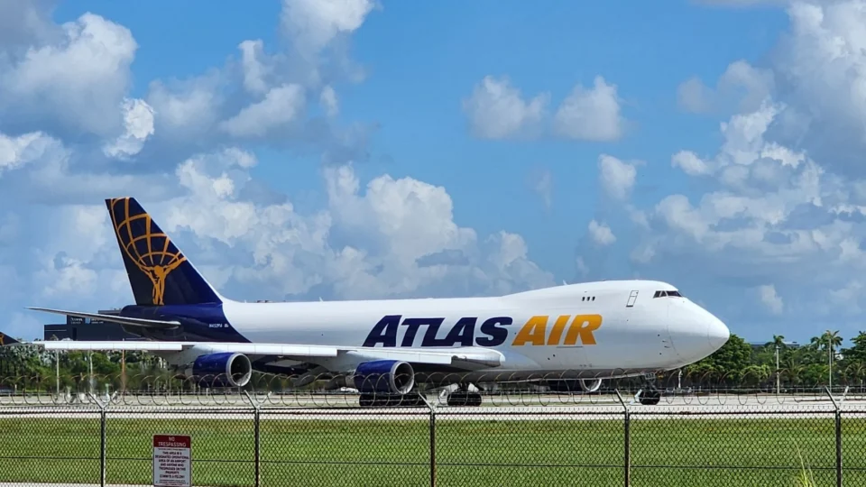 Atlas Air cargo plane taxiing on runway under a vibrant blue sky, captured outdoors.