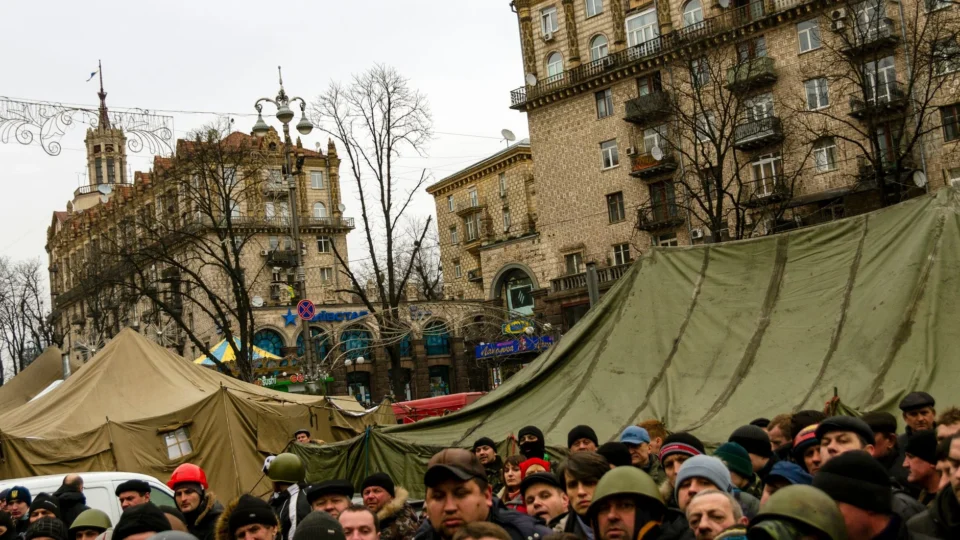 Large group of people gathered amid tents in Kyiv, Ukraine. Urban protest scene.