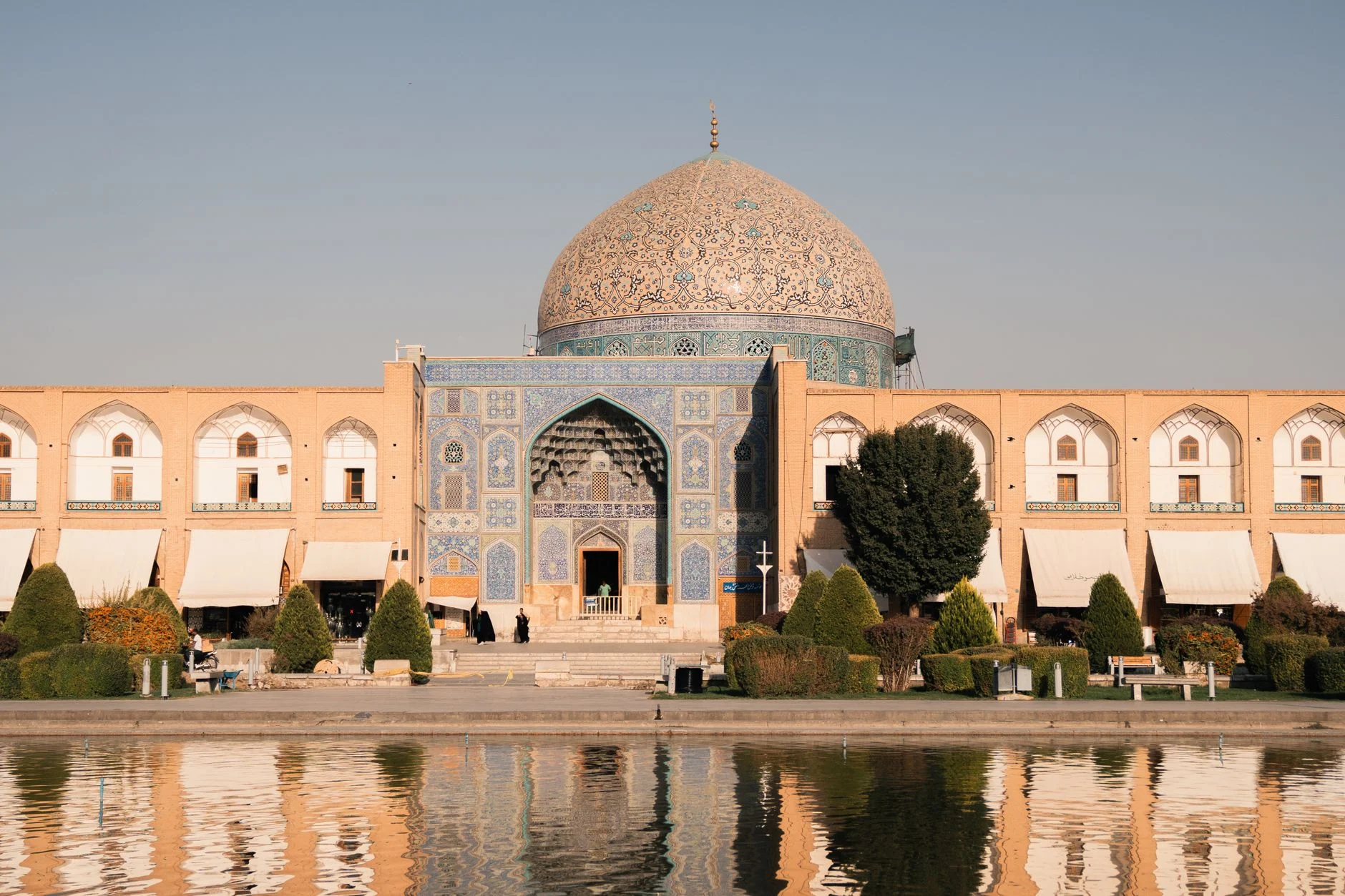 Beautiful view of Sheikh Lotfollah Mosque in Isfahan, Iran reflecting in a pond during the day.