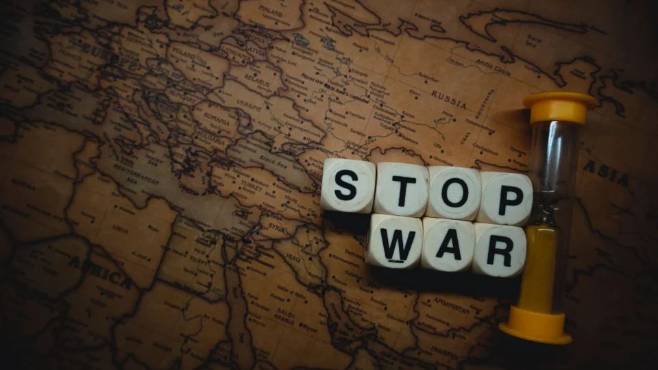 A powerful message 'Stop War' displayed on a vintage world map with an hourglass, symbolizing urgency and global issues.