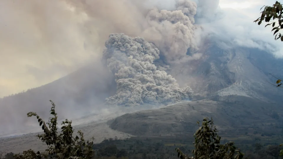 A powerful eruption of Mount Sinabung in North Sumatra, Indonesia, showcasing volcanic smoke and ash clouds.