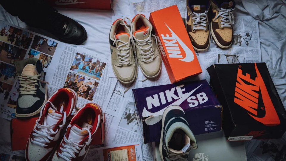 A variety of Nike sneakers displayed on newspapers with branded shoeboxes.