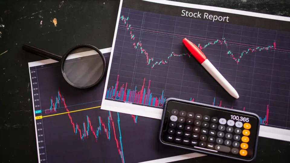Stock report with charts, calculator, and magnifying glass for financial analysis.