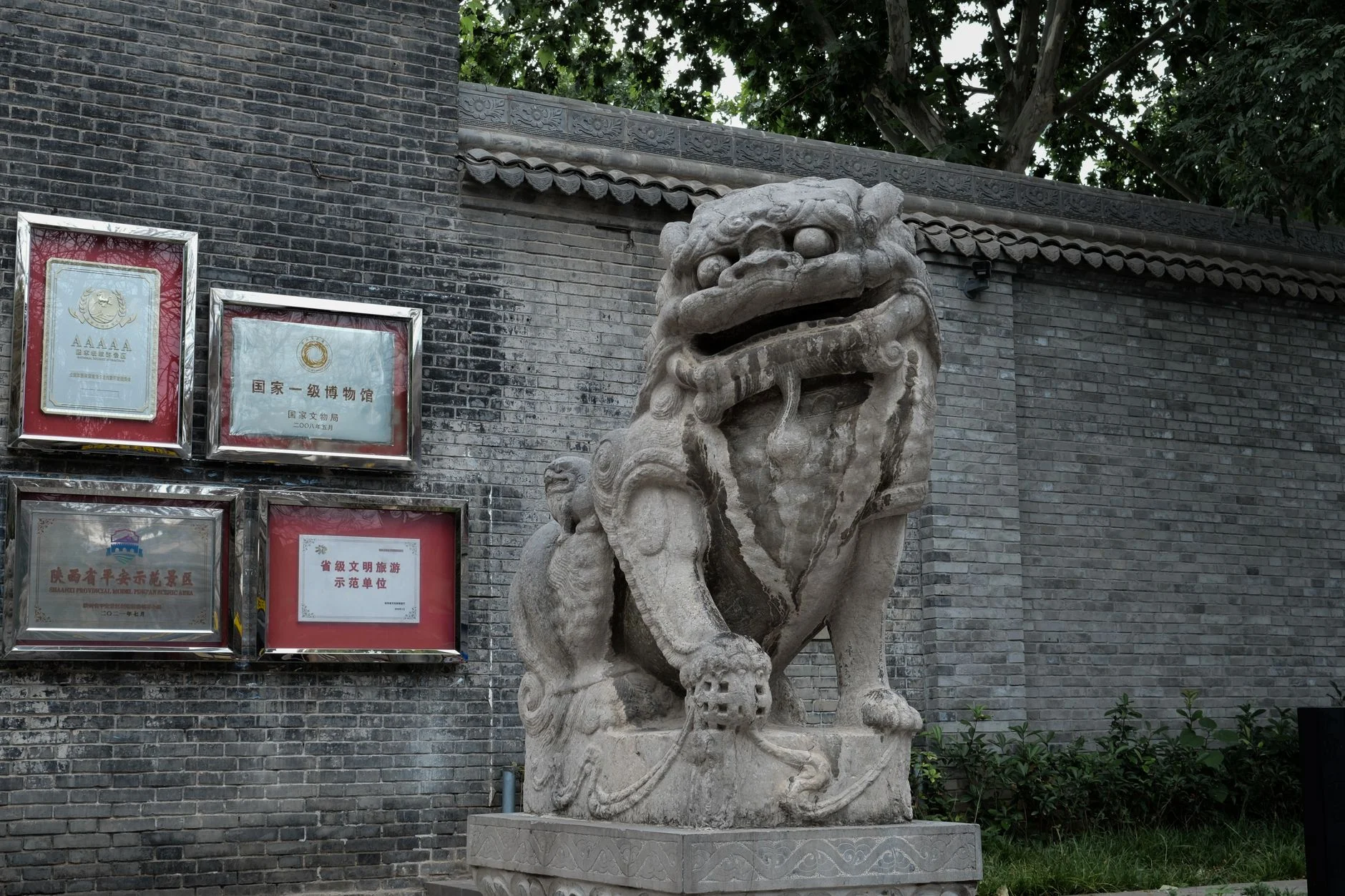 A detailed view of a traditional Chinese stone lion statue in Xi'an, Shaanxi Province.