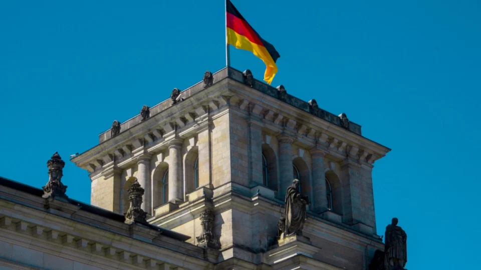 View of the Reichstag building's architecture with German flag flying high in Berlin.