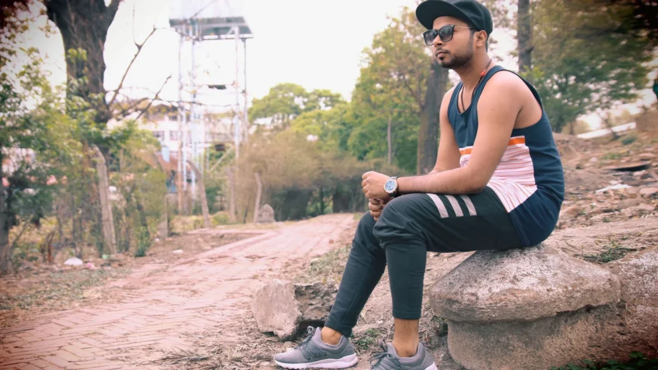 Casual outdoor portrait of a young man sitting on a rock in Kathmandu, Nepal.