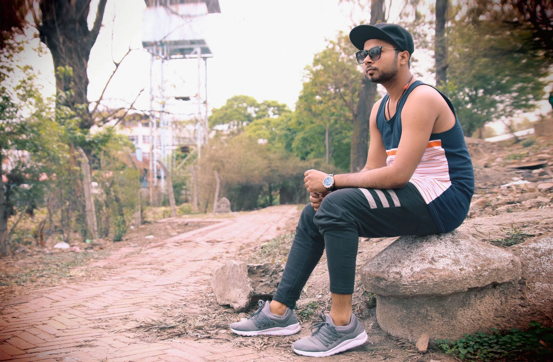 Casual outdoor portrait of a young man sitting on a rock in Kathmandu, Nepal.