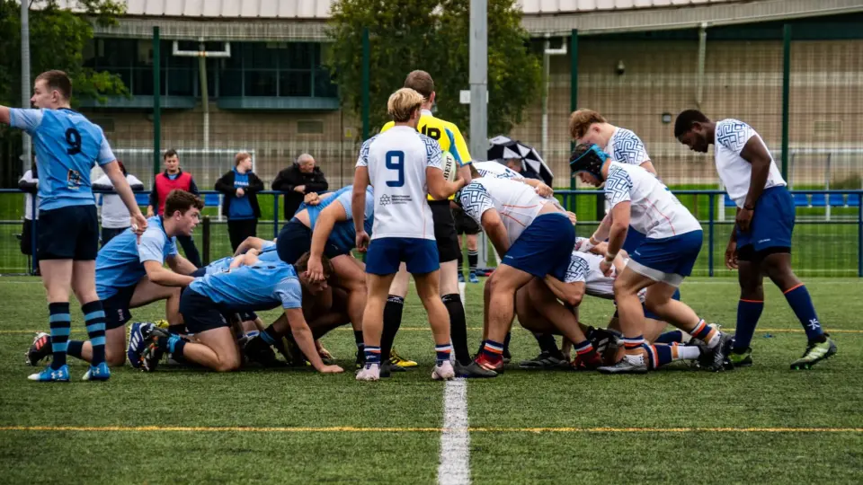 Rugby players in action during a competitive daytime match on a sports field.