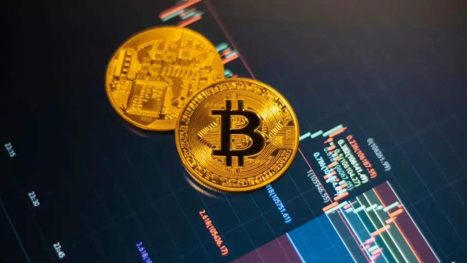 Golden Bitcoin coins on a digital stock market chart showcasing cryptocurrency trading.