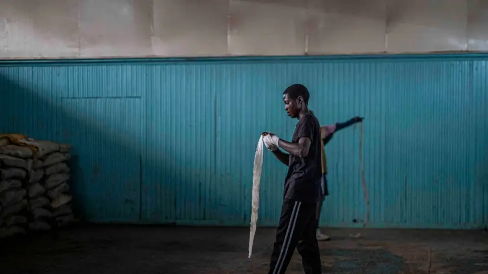 Young man wraps his hands for boxing training in an urban gym in Nairobi, Kenya.