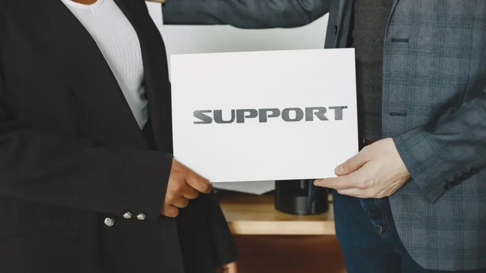 Business diversity and support concept with professionals holding a support sign.