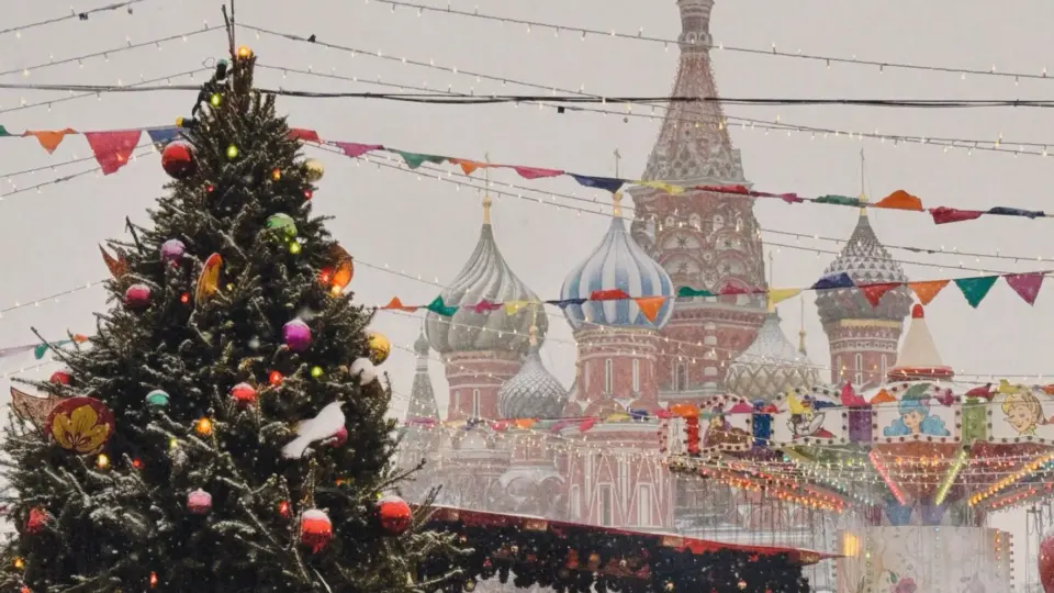 A snowy festive scene with a Christmas tree and St. Basil's Cathedral in Moscow, Russia.