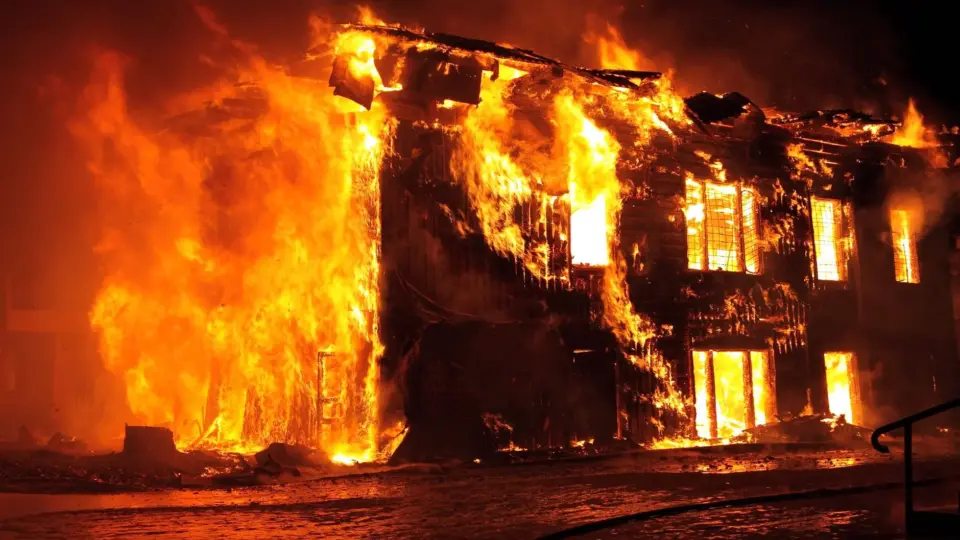 A dramatic nighttime scene of a house engulfed in flames in Tulan, Russia.