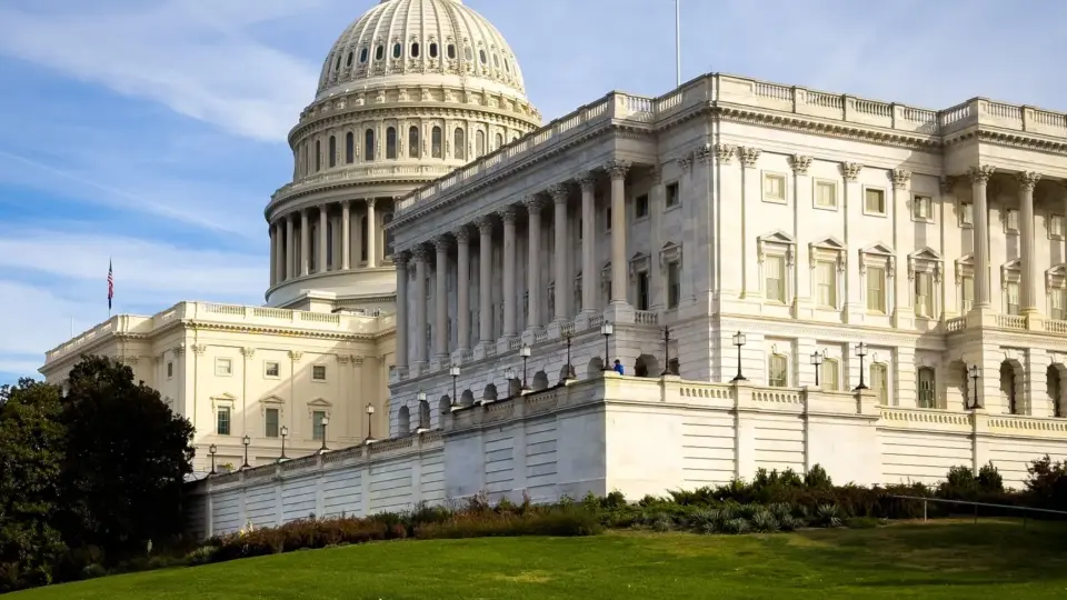 A picturesque view of the US Capitol Building in Washington, DC, under a clear sky.