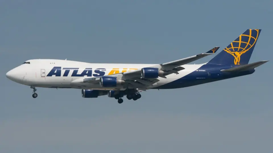 Boeing 747 with Atlas Air branding flying under clear blue sky, showcasing aviation.